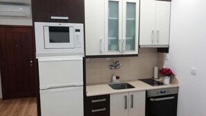 A compact kitchen with white cabinetry, a microwave, a sink, and a dishwasher. - Apartment in the Historic Center of the city, with balcony, air conditioning (Porto)