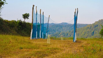 A cricket field with boundary ropes and stumps.