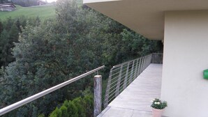 A balcony with a metal railing overlooking a lush green landscape and a mountain in the background. - Beautiful chalet - The mountains on the doorstep  (Vintl/Pfunders)