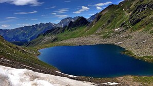 A mountainous landscape with a clear blue lake surrounded by rugged terrain and snow-capped peaks. - Beautiful chalet - The mountains on the doorstep  (Vintl/Pfunders)