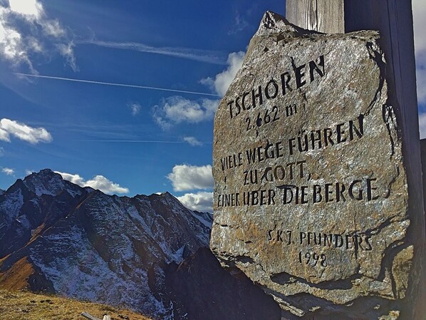 Un monumento de piedra con inscripciones, con montañas al fondo.