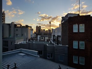 Paisaje urbano con edificios modernos, cielo despejado y atardecer.
