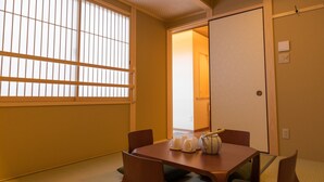 A traditional Japanese room with tatami flooring, a low wooden table with cushions, and sliding doors. - KumoMachiya Suieikaku (Kyoto)