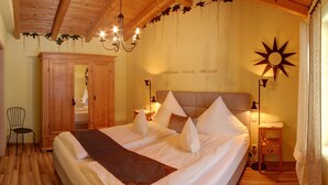 Ein Schlafzimmer mit einem großen Bett, einem Holzschrank und einer Pendelleuchte.