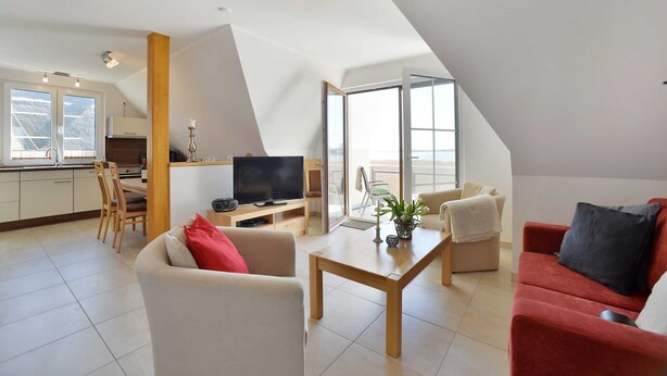 A modern apartment with a kitchen, dining area, and living room. - Boddenbrise Vacation Rental - General Suite (Breege)