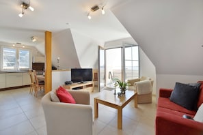 A modern apartment with a kitchen, dining area, and living room.