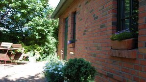 A brick building with a window planter and a potted plant in the foreground. - Apartment 1 - Apartments Meyer (Bollewick)