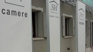 Une rangée de chambres dont les panneaux indiquent « cameri » et « rooms » pour indiquer qu’il s’agit d’hébergements.
