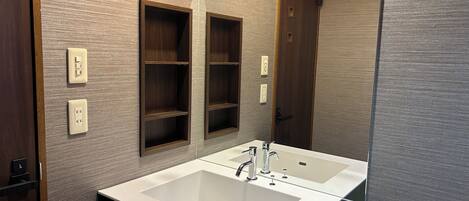 A bathroom with two sinks, a mirror, and wooden shelves.