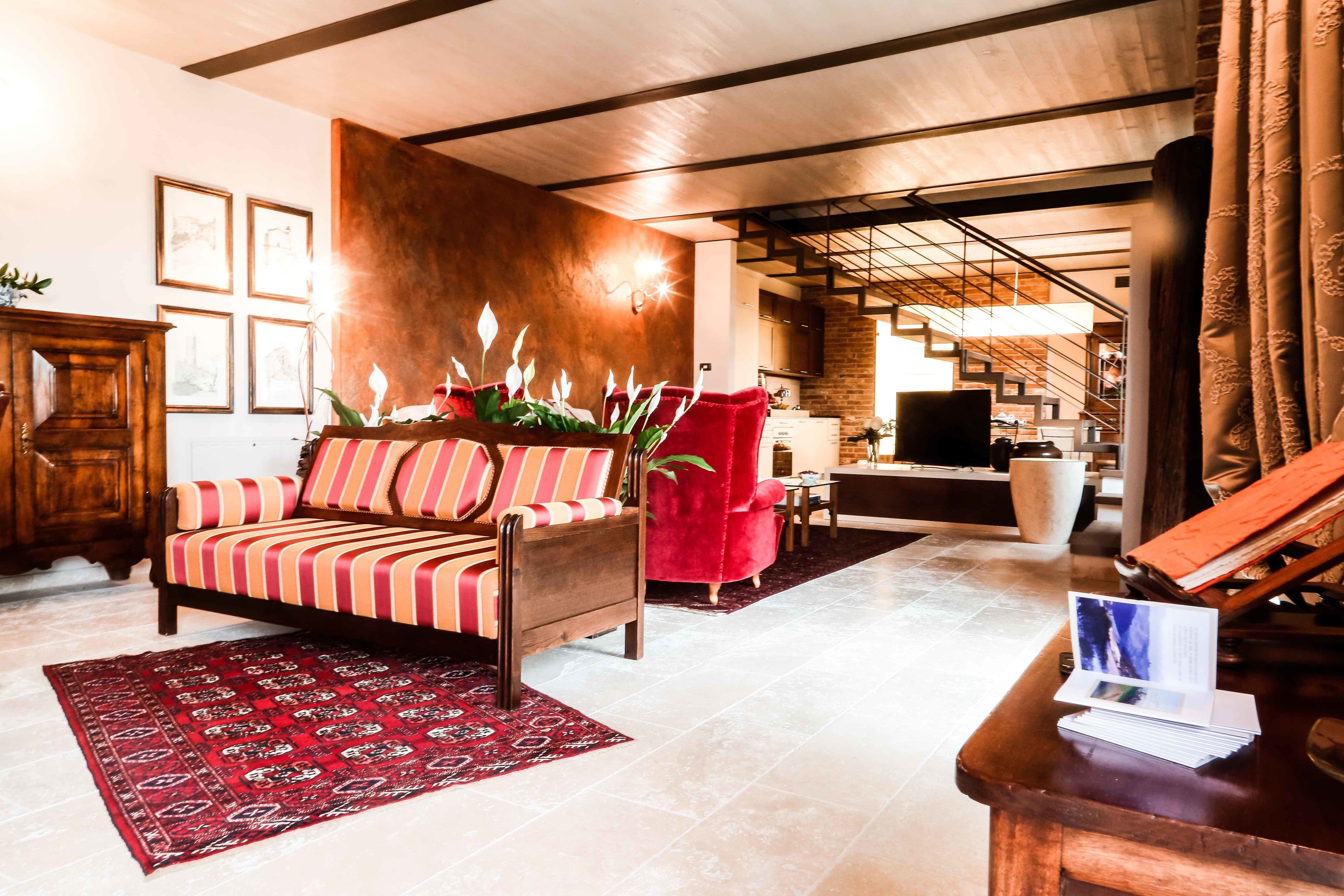 Una sala de estar moderna con un sofá, un sillón rojo y una mesa de centro de madera.