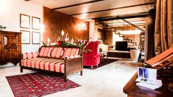 Una sala de estar moderna con un sofá, un sillón rojo y una mesa de centro de madera.