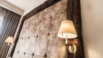 A tufted headboard with a wooden frame and two wall-mounted lamps.