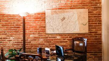 A conference room with a glass table, two chairs, a map on the wall, and a lamp.