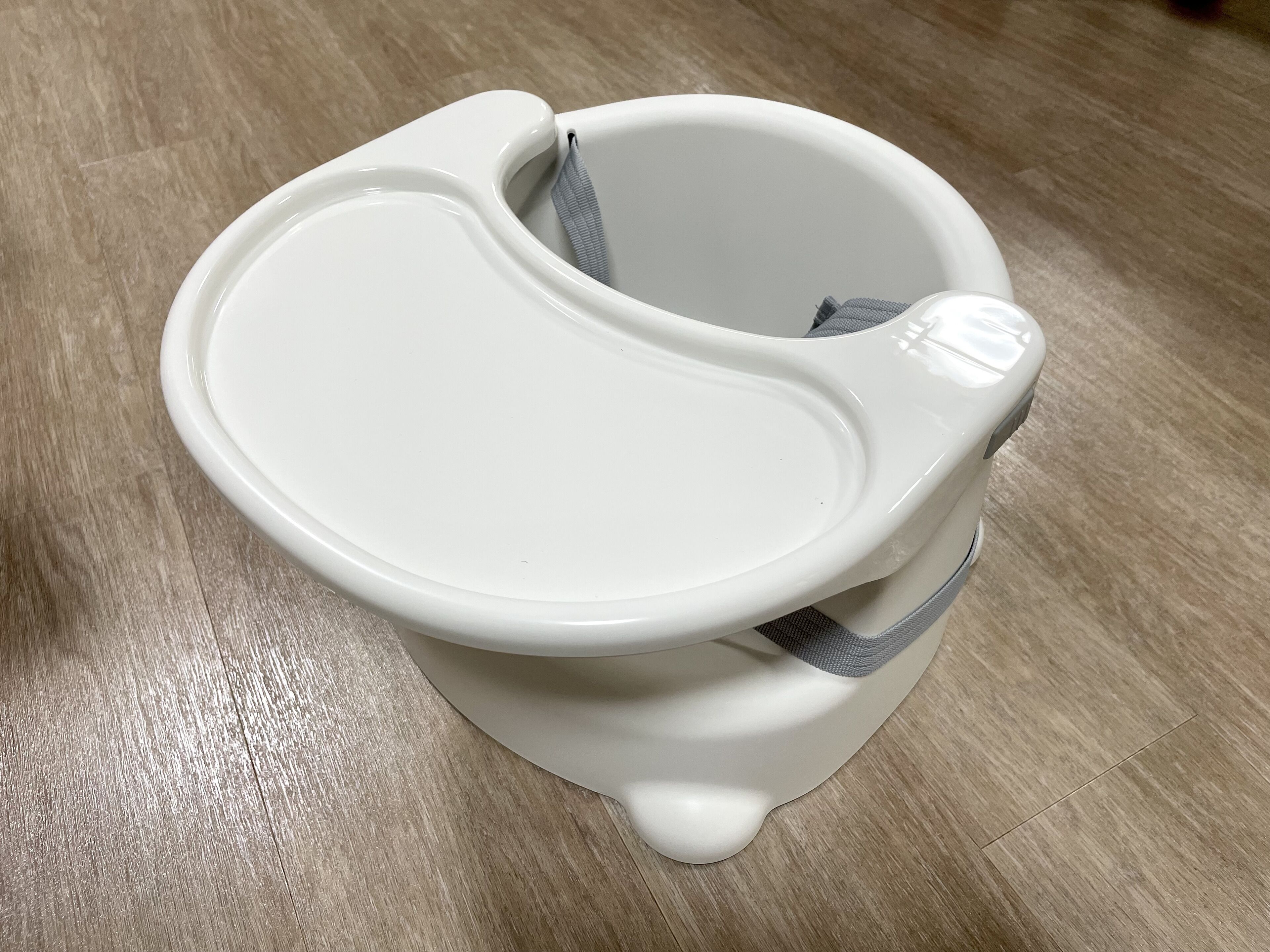 A white toilet with a seat cover and a footrest.