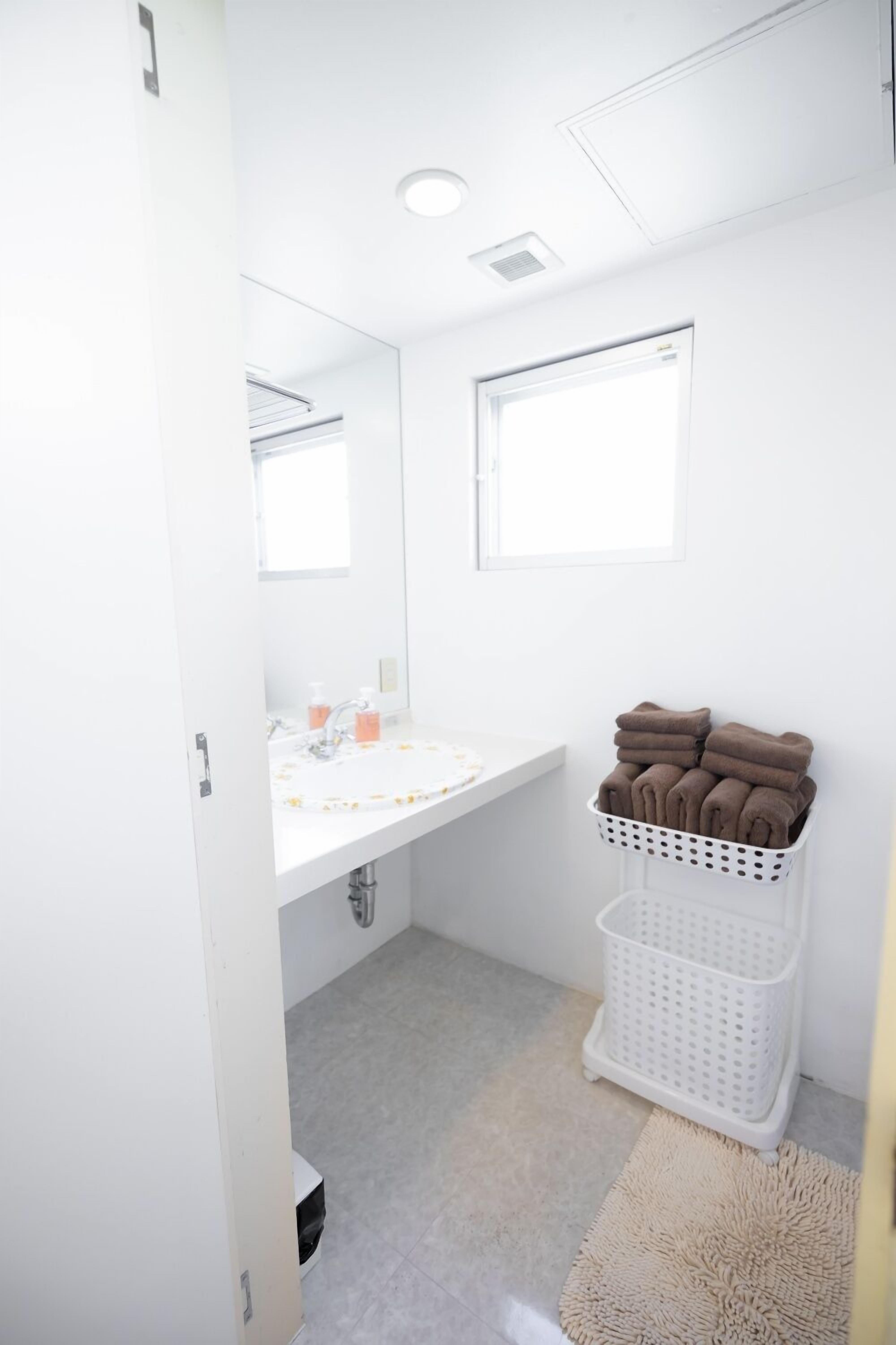 A bathroom with a white sink, mirror, and towel rack.