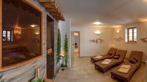 Ein Wellnessbereich mit einer Holzbank, einer Massageliege und einer Wand mit einem Bergfries.