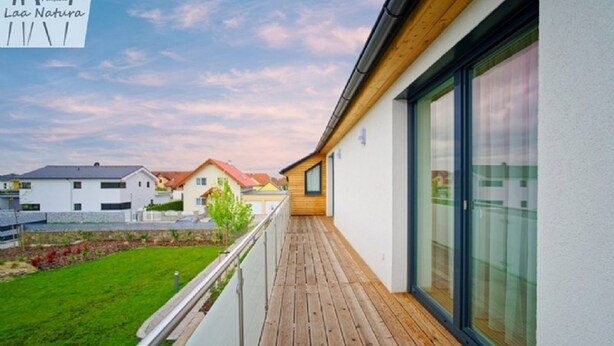 A modern residential building with a wooden deck and large windows. - Pension Laa Natura (Laa an der Thaya)