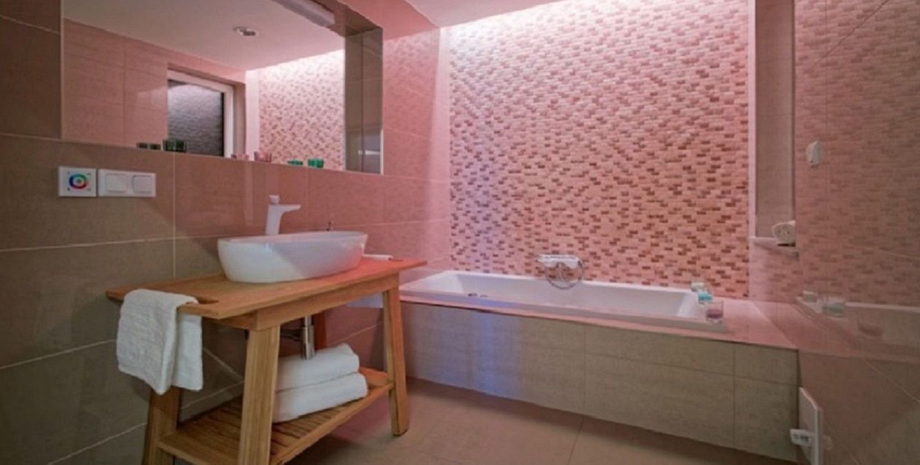 Une salle de bain avec un meuble-lavabo en bois, un lavabo blanc et une baignoire.
