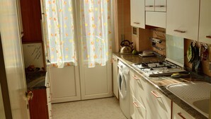 Eine Küche mit Herd, Backofen und Schränken.