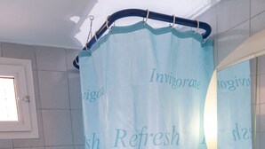 A bathroom with a shower curtain featuring the words "Invigorate," "Refresh," and "Bath." - Chris Apartments (Kassandra)