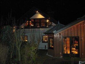A two-story building with a sloped roof and a balcony. There is a wooden fence surrounding the property. - Haus Sonnenhügel (Winterberg)
