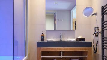 Une salle de bain moderne avec une douche à parois de verre, un meuble-lavabo en bois avec un miroir et un porte-serviettes.