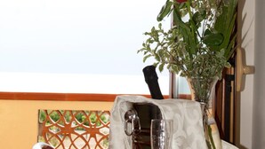 A dining table with a vase of flowers, a wine glass, and a chair.