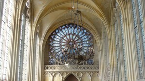 A church interior with arched ceilings, stained glass windows, and wooden pews. - B&B L'Etape Normande & SPA (Montroty)