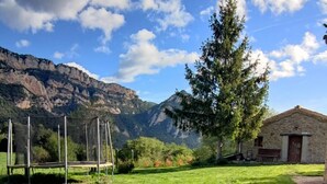 Un letrero de bienvenida en un área con césped, con montañas al fondo.