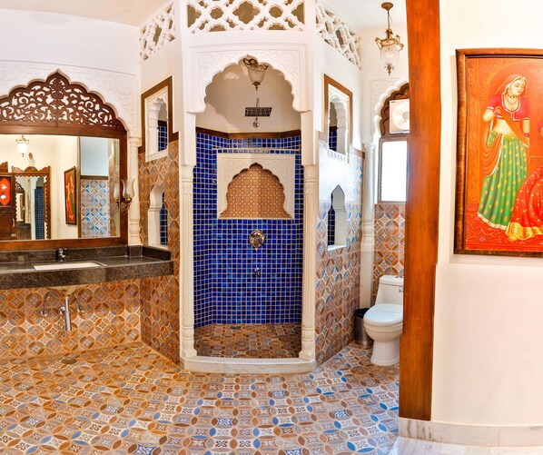 A bathroom with blue mosaic tiles, a shower, a toilet, and a mirror. - Hotel Pearl Palace (Jaipur)