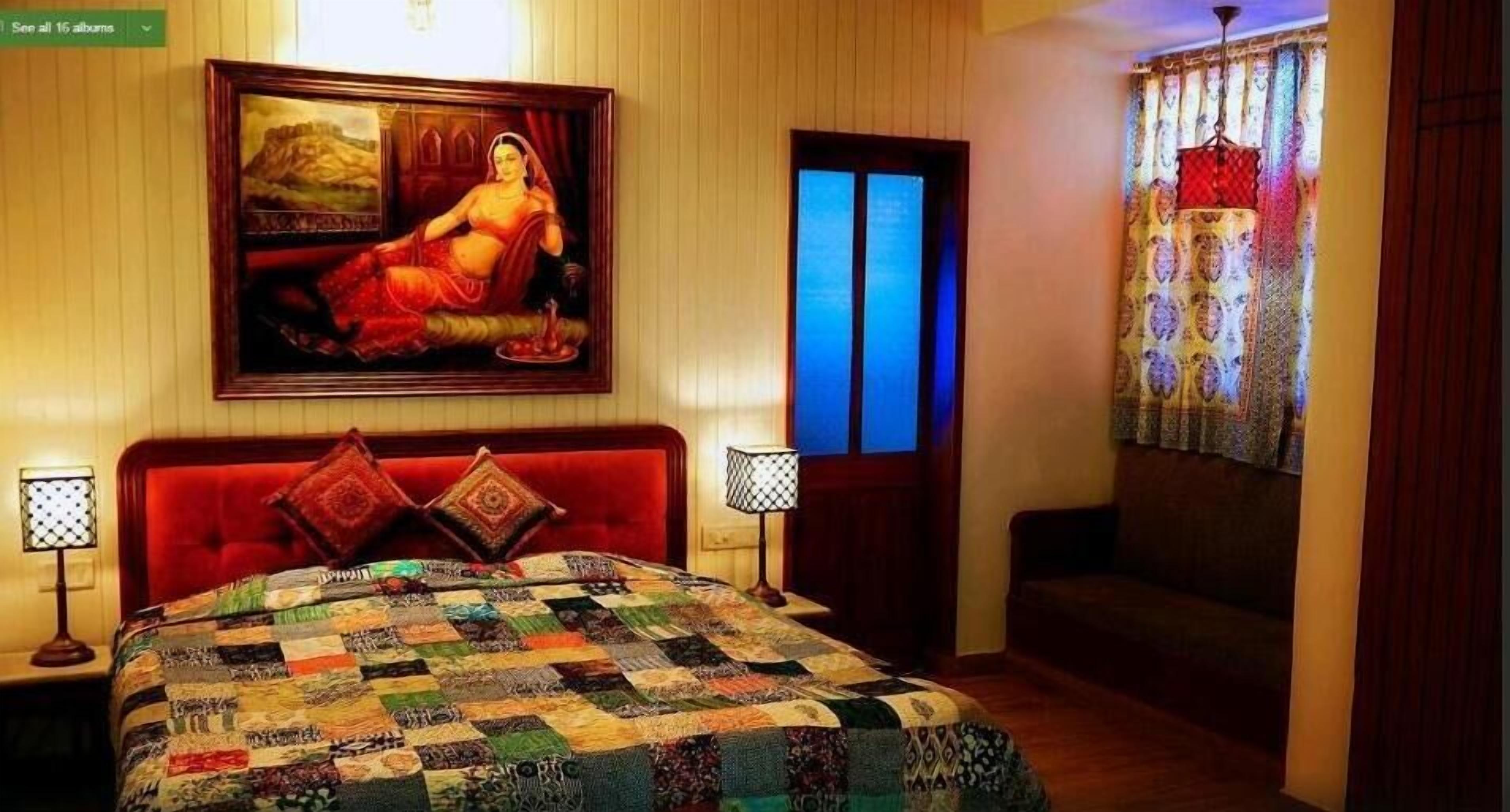 Un dormitorio con una cama grande, un cuadro en la pared y una ventana con cortinas.