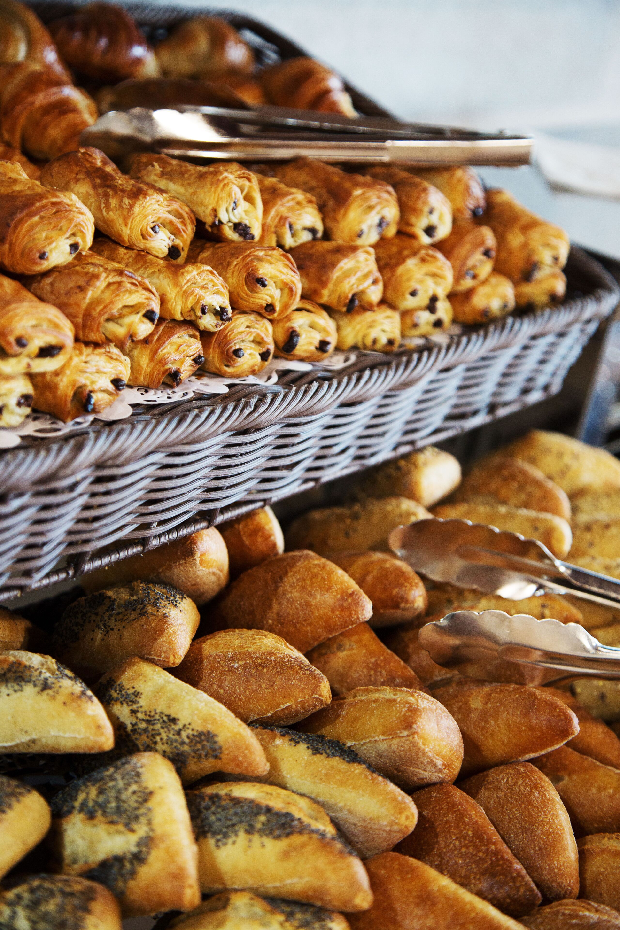 A variety of baked goods, including croissants and bread rolls, arranged on a table.