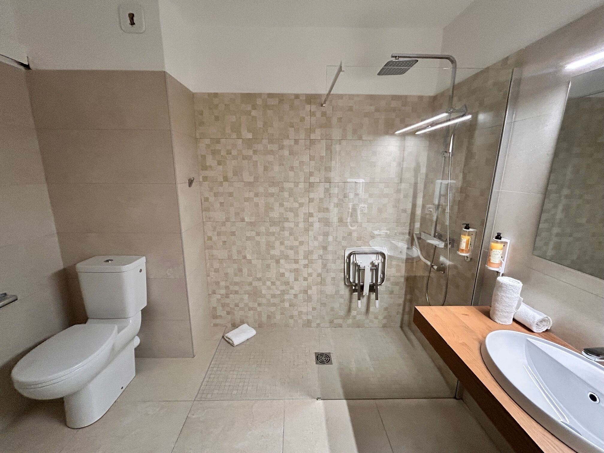 A modern bathroom with a toilet, shower, and sink.