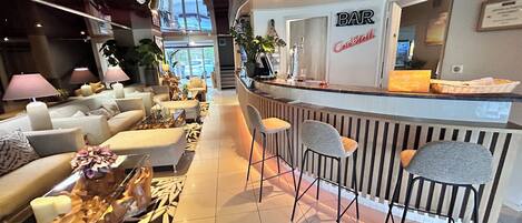 A bar area with a counter, seating, and a view of the outside.