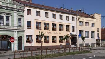 A hotel building with multiple windows and a sign indicating it is a hotel.