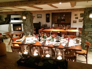 Un comedor con chimenea de piedra, mesas y sillas de madera.