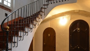 Eine prächtige Treppe mit schmiedeeisernem Geländer, die zu einer oberen Etage führt.