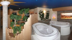 Un área de spa con dos jacuzzis, una pared vegetal de madera y una pared de piedra con chimenea.
