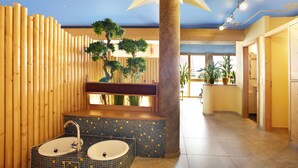 Un baño con dos lavamanos, una columna grande y un techo con diseño de estrellas.