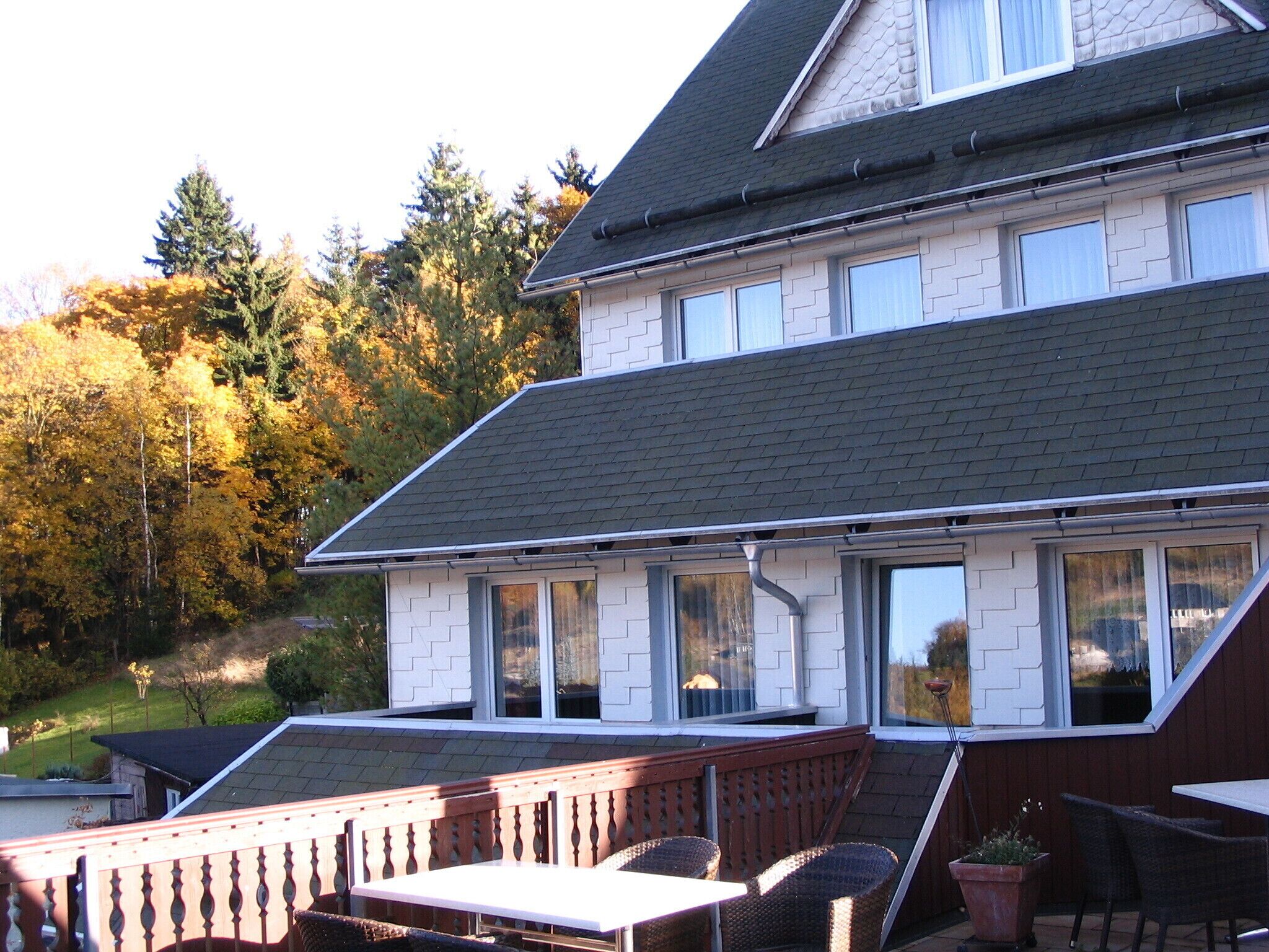 A two-story house with a balcony and a patio area.
