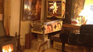 A cozy room with a fireplace, a wooden table, a chair, and a television. - Les Milles et une Nuits (Sisco)