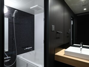 Ein modernes Badezimmer mit Badewanne, Dusche und Waschbecken.