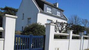 A two-story house with a white exterior, a blue gate, and a sign indicating a private property. - Large house, on land of 1000m2, 150m from the beach, 4 bedrooms, WIFI (Concarneau)