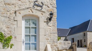 A stone building with a white door, a set of stone steps leading up to it, and a small wooden bench in the foreground. - Luxury Cottage, Outdoor Nordic Hot Tub and Sauna, D-Day Beaches 15 km (Isigny-Sur-Mer)