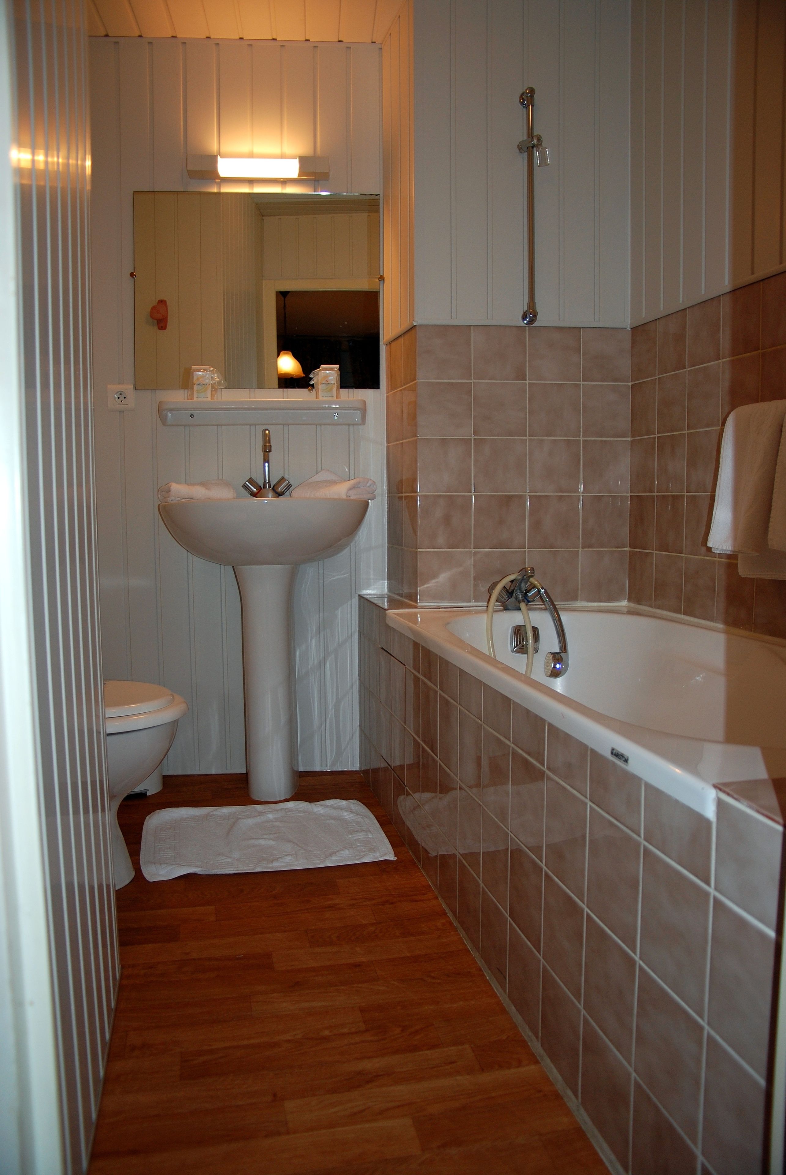 Un bagno con lavandino, water e vasca da bagno bianchi.