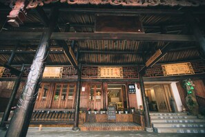 A traditional wooden building with a wooden staircase leading to the entrance. - Stay in joy Boutique Inn (Qiandongnan)