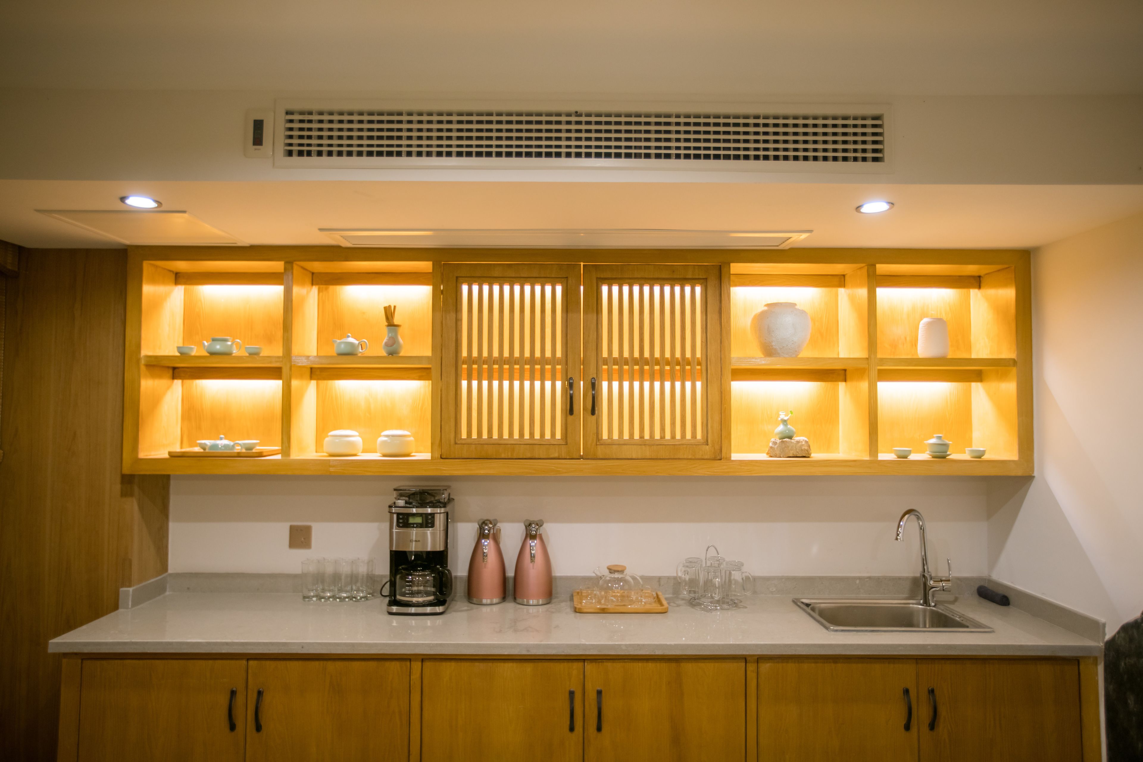 A kitchen with wooden cabinets, a countertop, a sink, and various kitchen items.