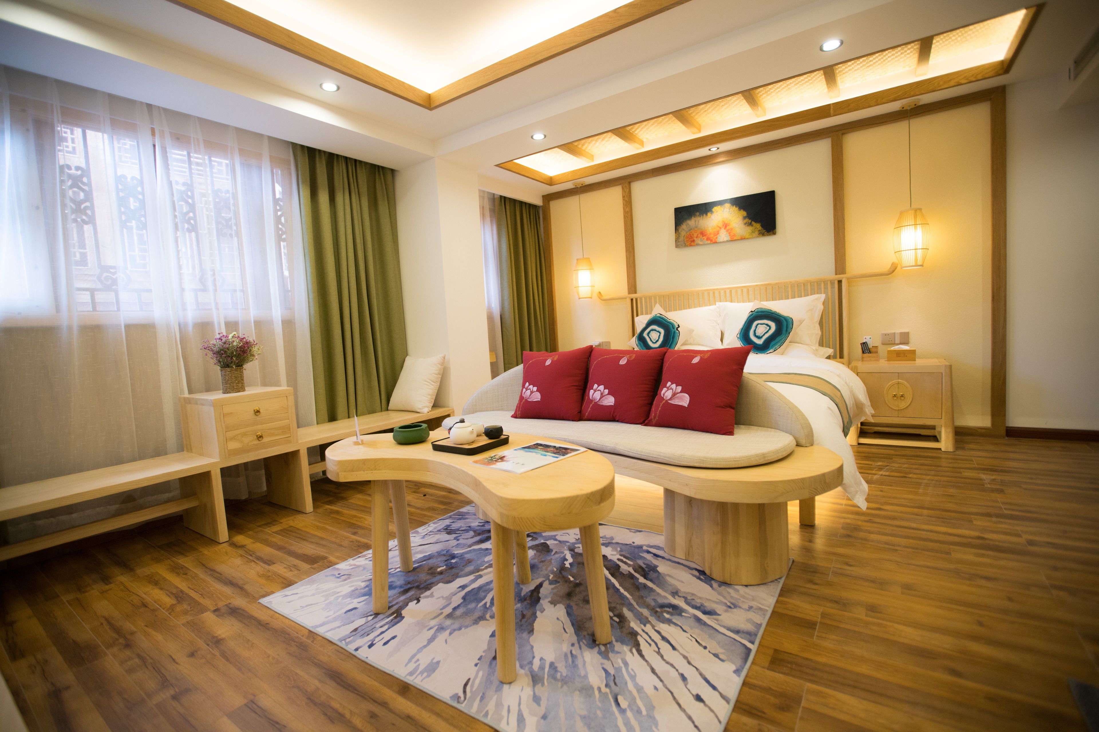 A modern bedroom with a bed, bedside tables, a nightstand, a desk, and a chair.