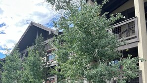 A multi-story building with balconies, a parking area, and a sign indicating a 15-minute parking limit. - Luxury Remodel Downtown Condo Across from Yampa River 
CANNOT BEAT THE LOCATION! (Steamboat Springs)