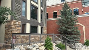 A building with a stone facade, large windows, and a red roof. - Luxury Remodel Downtown Condo Across from Yampa River 
CANNOT BEAT THE LOCATION! (Steamboat Springs)